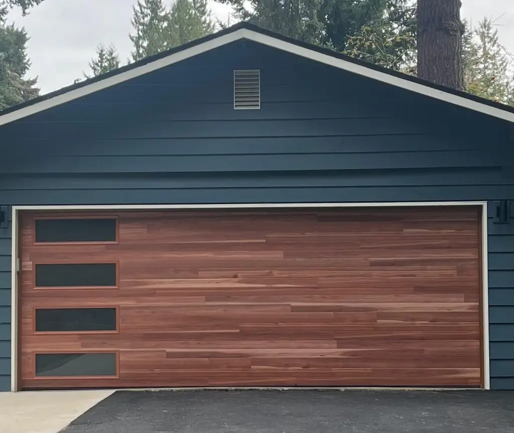 Beautiful double car garage door with a wood-like finish with windows.